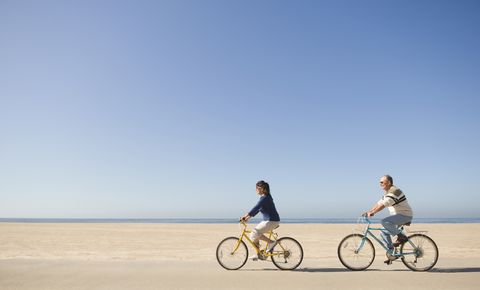 Couple riding bicycles on beach