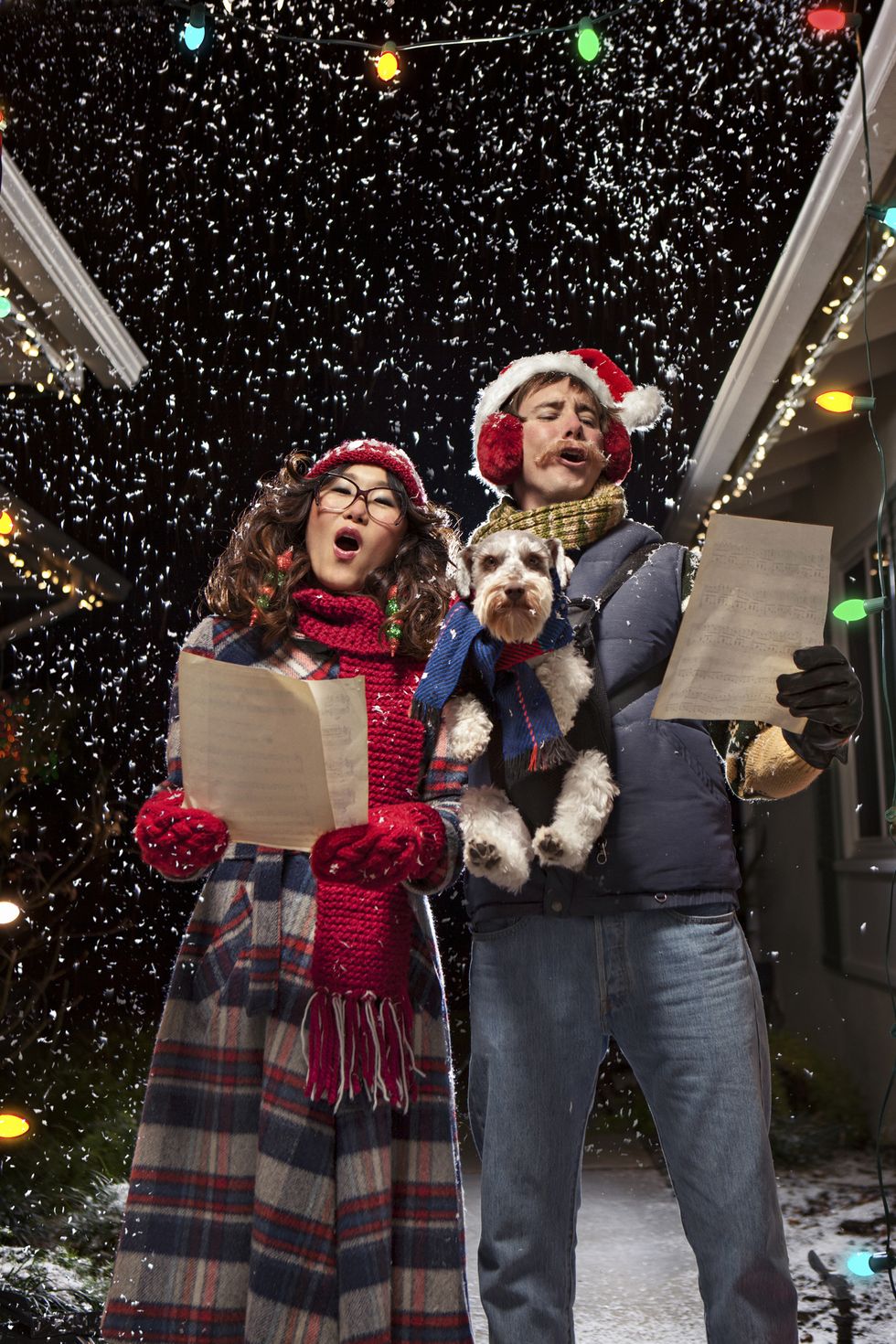 couple singing christmas carols with dog