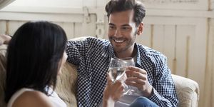 couple sitting on sofa talking and drinking wine