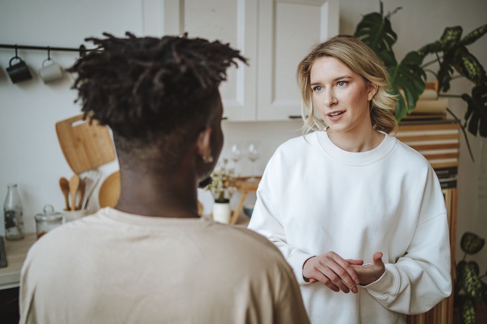 couple standing face to face and talking in kitchen