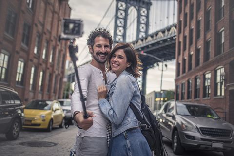 Couple taking photo with selfie stick, Brooklyn, New York, US