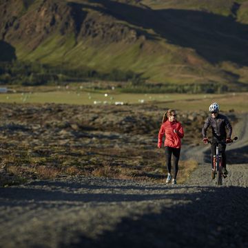 couple talking together while biking and running