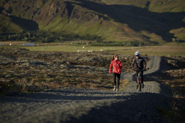 couple talking together while biking and running