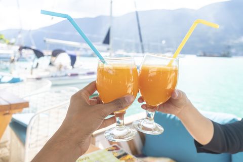 couple toasting with cocktail on boat, lefkada island, levkas, greece