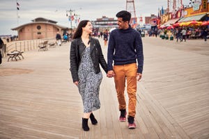 couple walking on boardwalk at amusement park