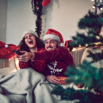 couple watching a movie on christmas eve in bed