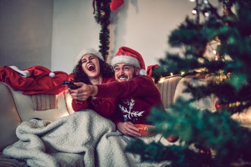 couple watching a movie on christmas eve in bed