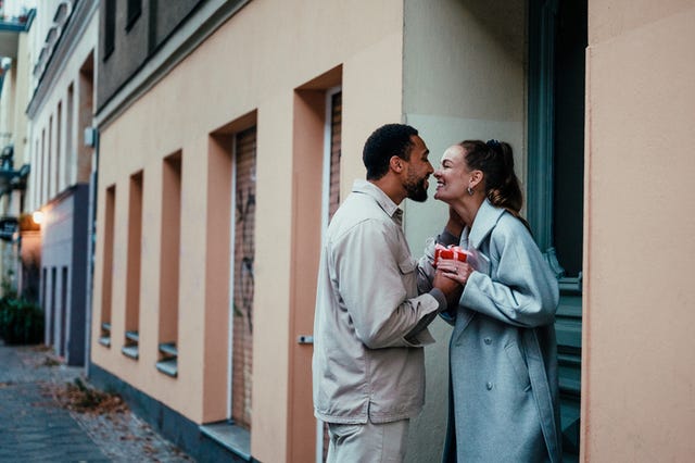 couple with a holiday present on a doorstep