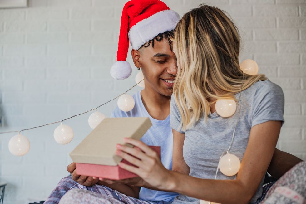 couple with christmas presents in bed during holidays