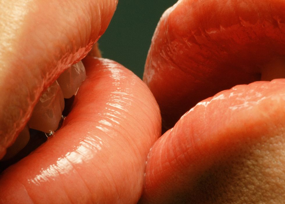 couple with glossy lips kissing, close up