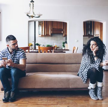 couple with relationship difficulties sitting on sofa at home