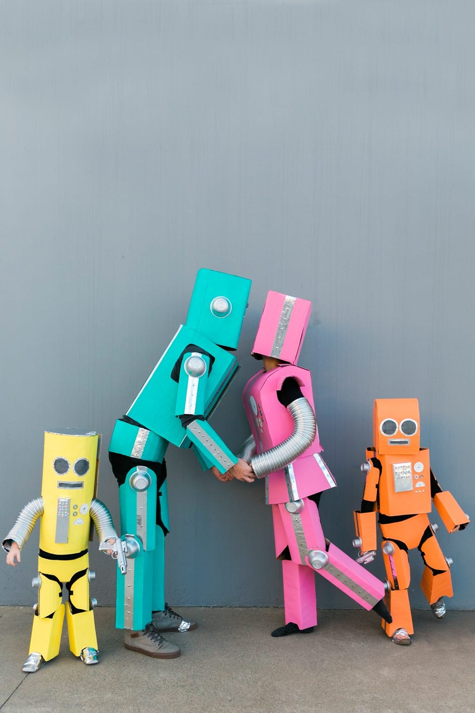 couples costumes, a man and woman with their two kids dressed as colorful robots