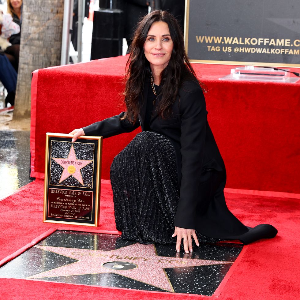 courteney cox smiles at her star on the hollywood walk of fame