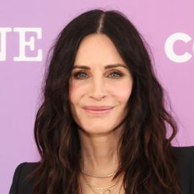 courteney cox smiles as she attends event wearing smart black suit