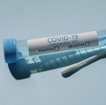 covid 19 test vial and swab on blue background
