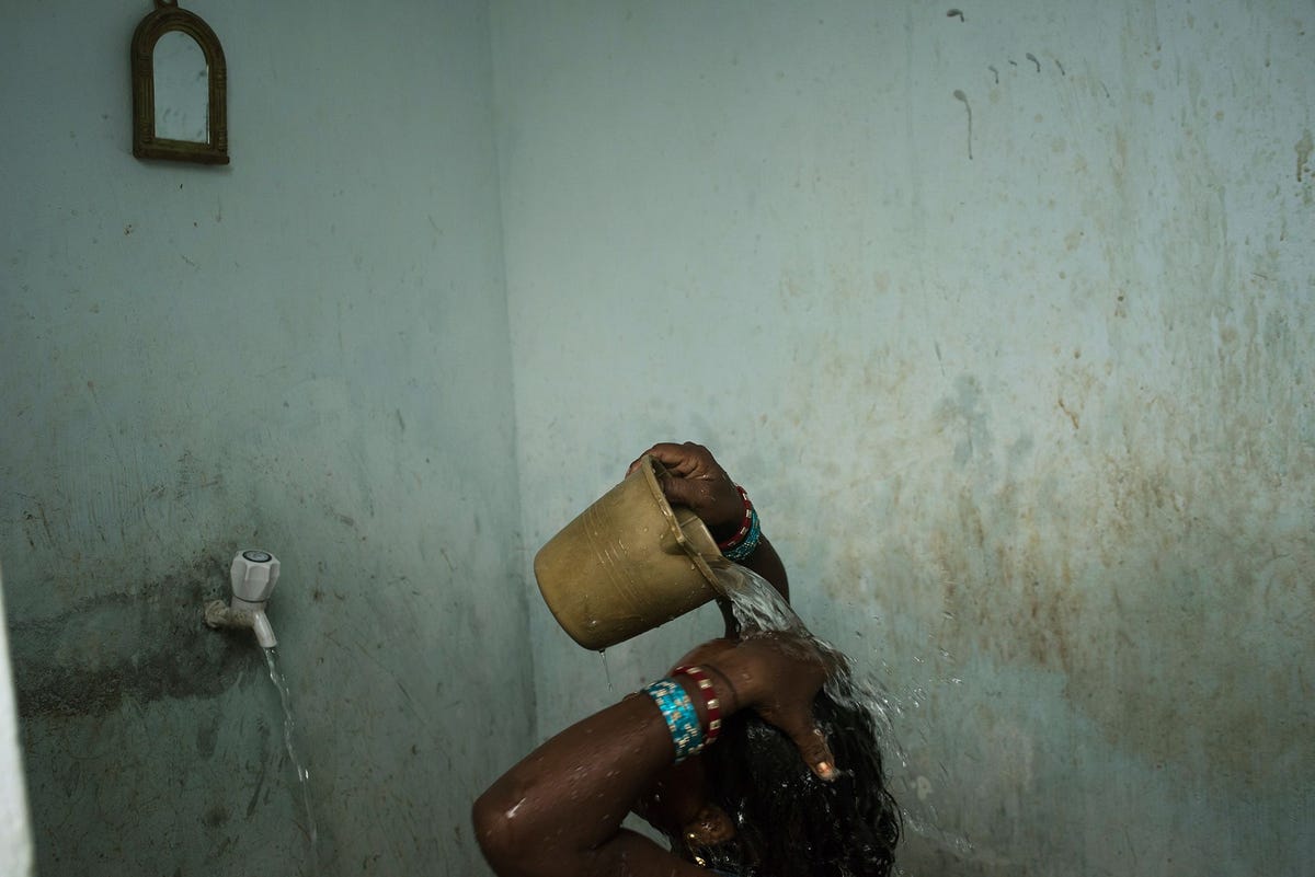 Een vrouw wast zich in de buurt van Bhubaneshwar een stad in de OostIndiase deelstaat Odisha Zelfs in de Indiase steden hebben de meeste inwoners geen toegang tot stromend water op het platteland moet 82 procent van de Indirs het zonder stromend water doen