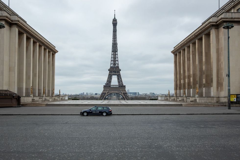 Agenten in een eenzame politiewagen zien erop toe dat de lockdown wordt nageleefd op Place du Trocadero langs de Seine aan de voet van de Eiffeltoren De lockdown is verlengd tot 15 april nu het aantal doden door COVID19 blijft toenemen