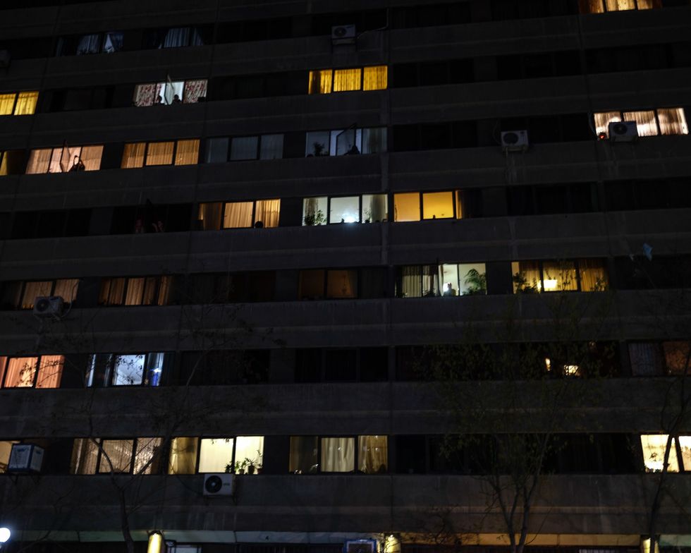 In het appartementencomplex Ekbatan in het westen van Teheran komen de bewoners om acht uur s avonds naar het raam om te dansen en te zingen In dit uitgestrekte wooncomplex bevinden zich duizenden mensen in quarantaine