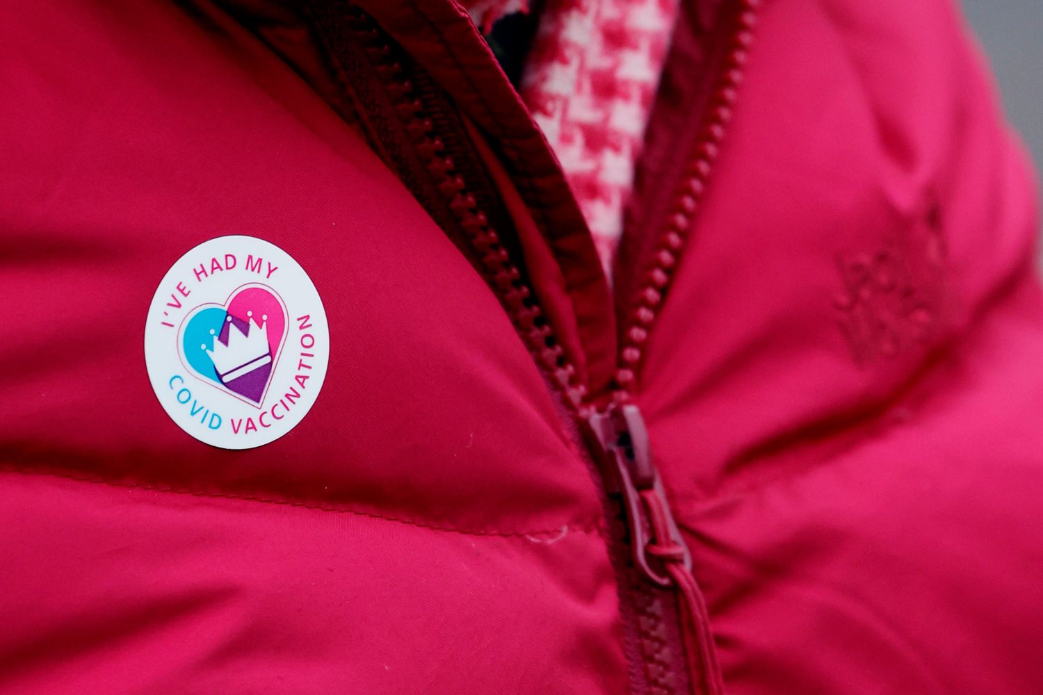 person wearing a covid vaccination sticker on their jacket
