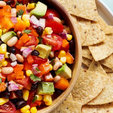 beans, tomatoes, red onion, and avocado in a bowl with chips