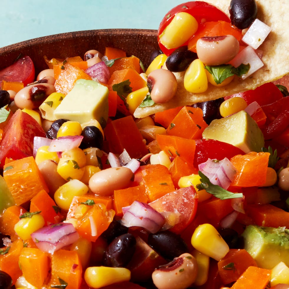 beans, tomatoes, red onion, and avocado in a bowl with chips