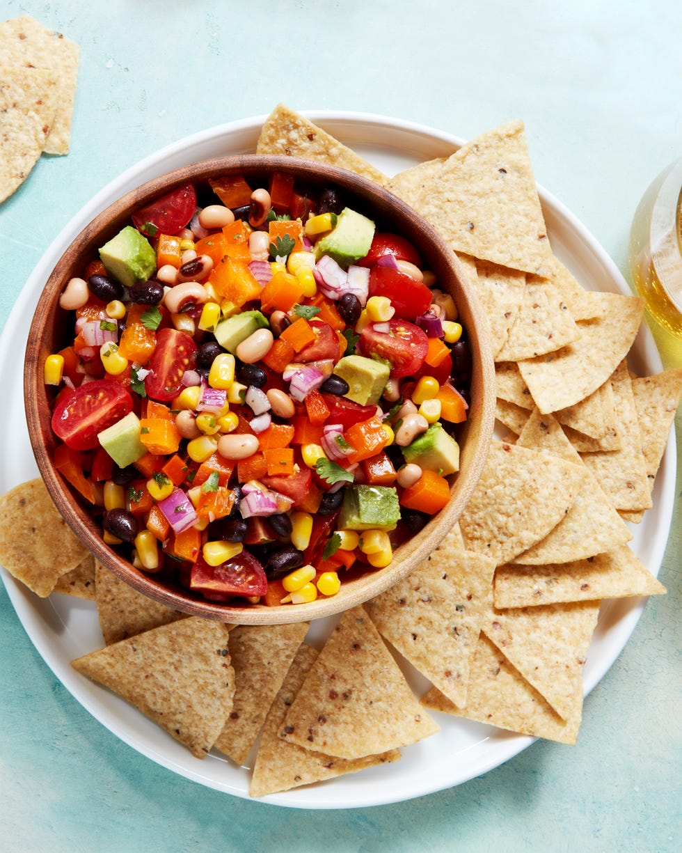 beans, tomatoes, red onion, and avocado in a bowl with chips