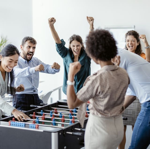 coworkers playing table football