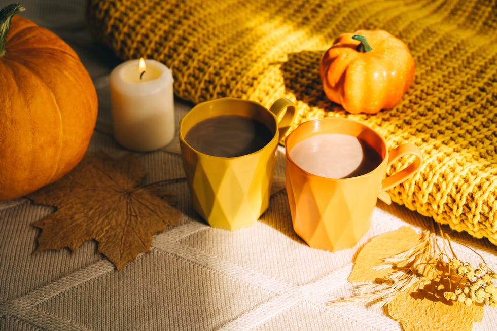 cozy autumn background with pumpkin and cups of cocoa in beige and orange colors