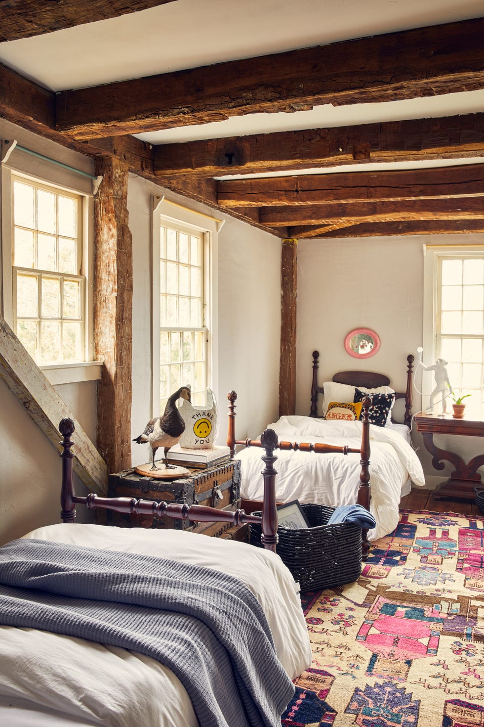guest bedroom with two twin bed and colorful patterned rug