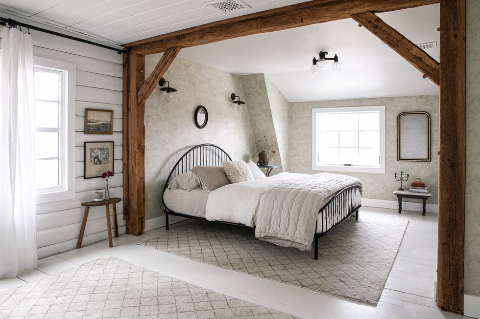 a bedroom in a log cabin that is mostly white and super cozy