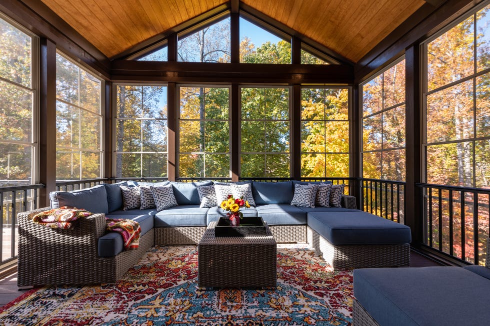 fall porch decor, cozy furnished porch enclosure in autumn season with wicker furniture and colorful distressed area rug