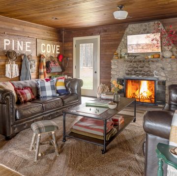 a cabin with a leather sofa and a stone fireplace