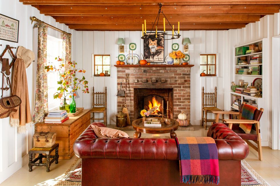 a cozy living room with a fireplace and wood paneled walls painted white