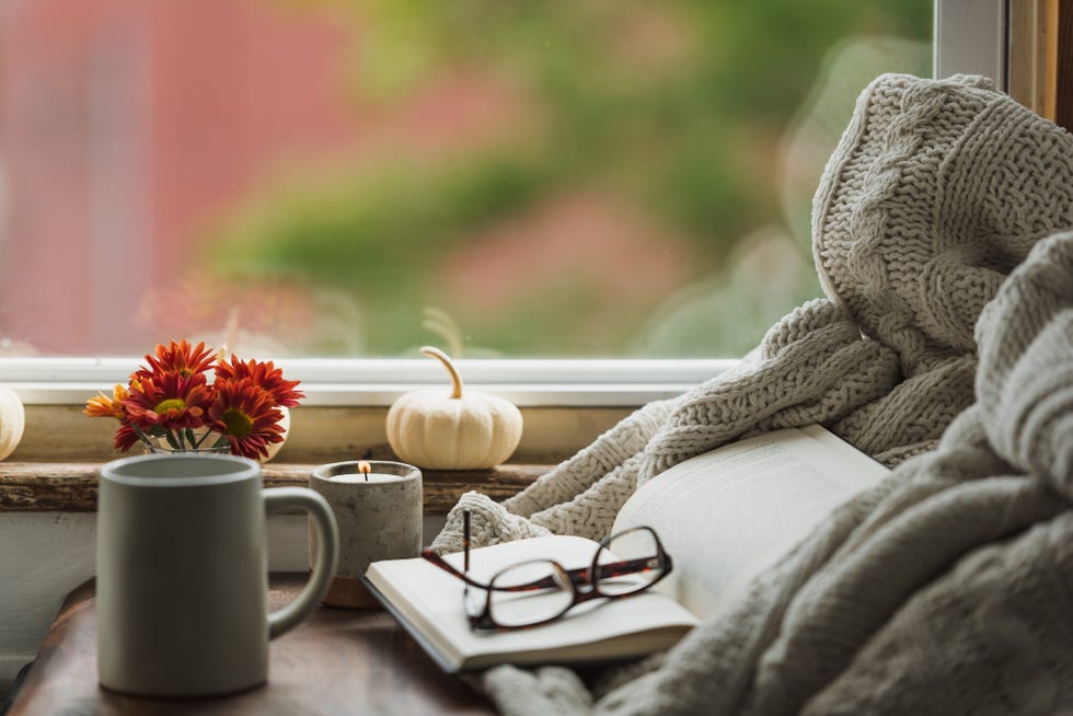 a cozy reading nook in the fall with a blanket and coffee