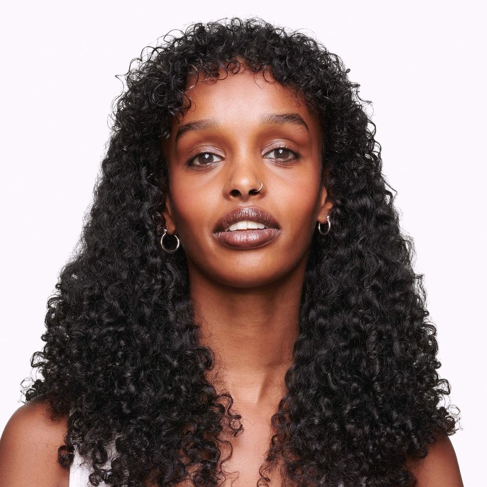 an east african woman with long curly hair extensions