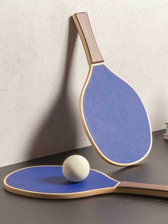 table tennis paddles and a ball on a surface