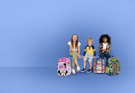 children sitting with colorful backpacks against a blue backdrop
