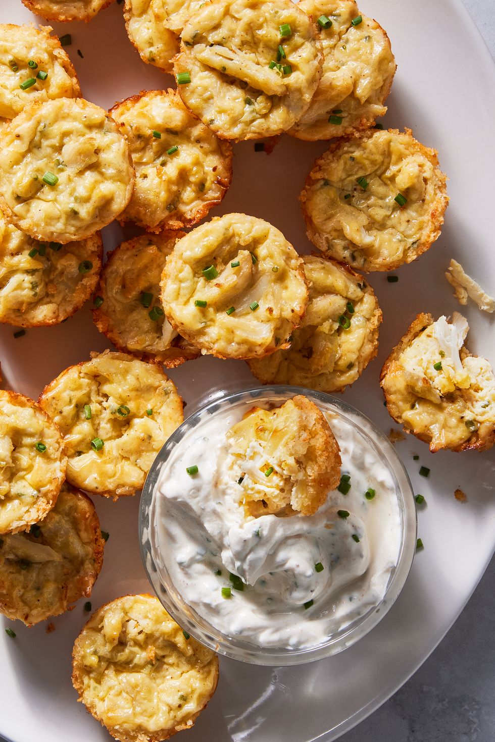 crab cake bites on a platter next to a dish of white chive dip