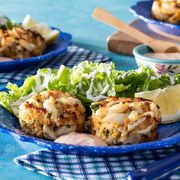 crab cakes two on blue plate with side salad