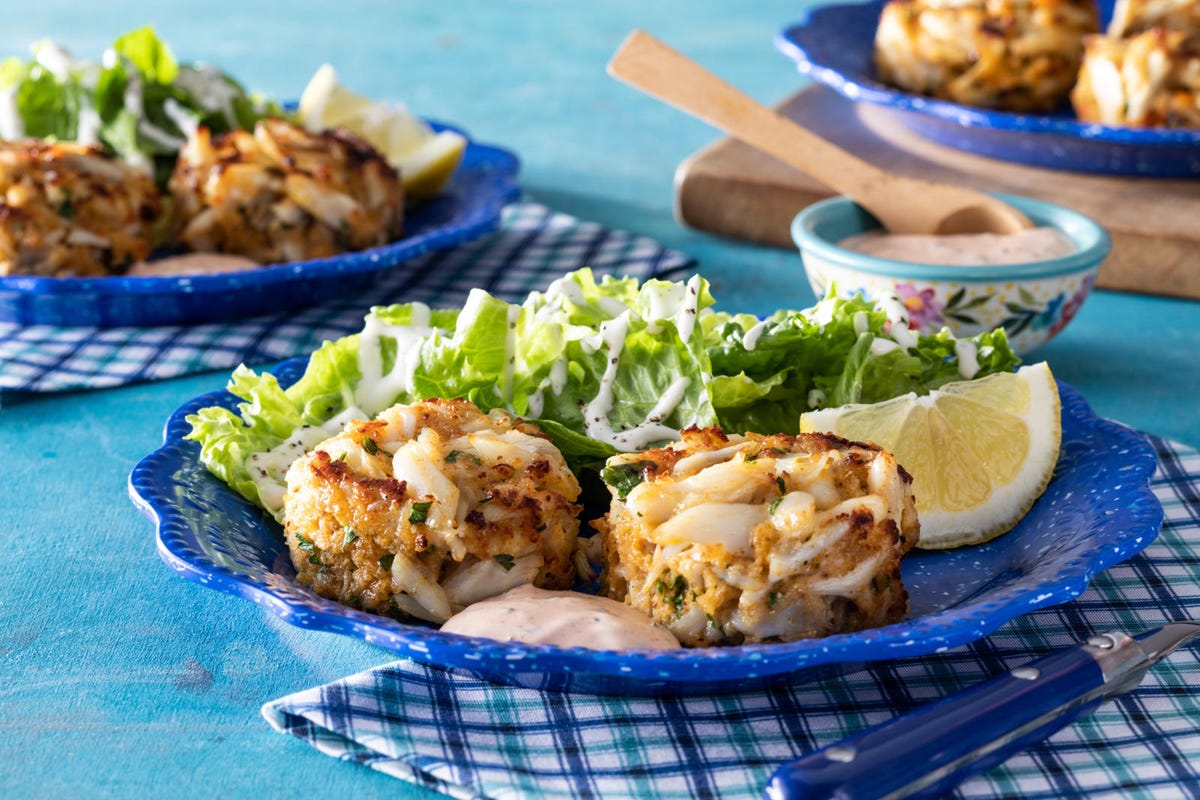 crab cakes two on blue plate with side salad