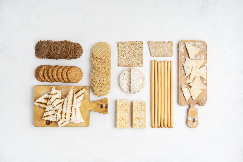 assorted healthy snacks, crackers, wafers, chips, cookies, grissini, wholegrain with rice and corn viewed from above in knolling style