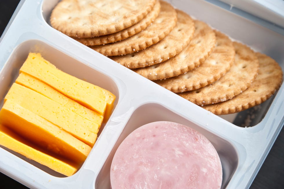 Crackers, sliced cheese and ham in a plastic tray
