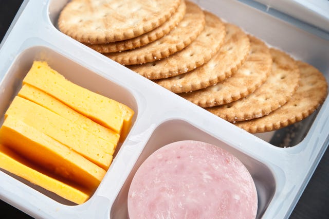 crackers, sliced cheese and ham in a plastic tray