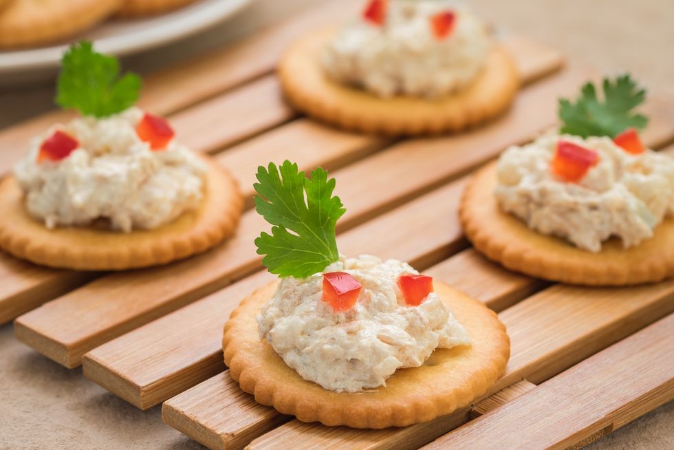 Crackers with tuna salad on wooden plate