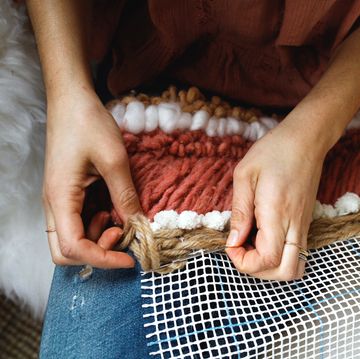 woman making tapestry with yarn