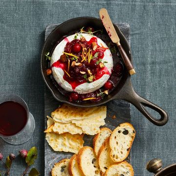 baked brie with cranberry syrup on top in a mini cast iron pan