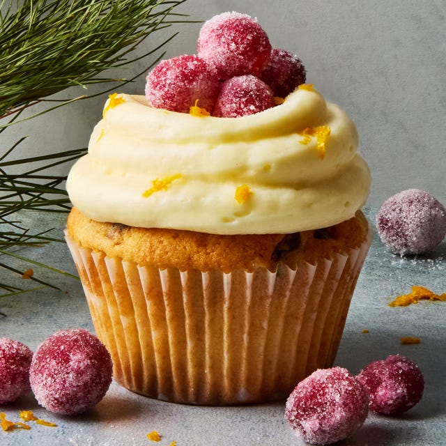 cupcakes topped with icing and sugared cranberries