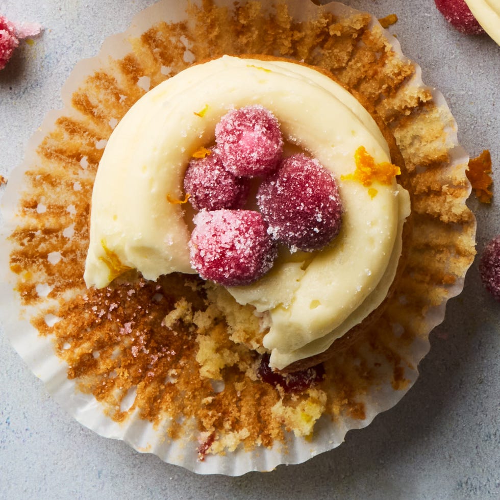 cupcakes topped with icing and sugared cranberries