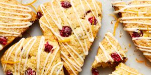 cranberry orange scones drizzled with glaze and topped with sanding sugar