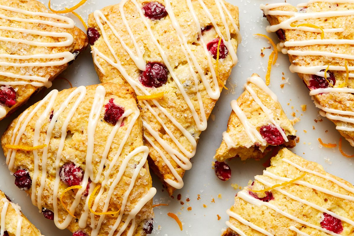 cranberry orange scones drizzled with glaze and topped with sanding sugar